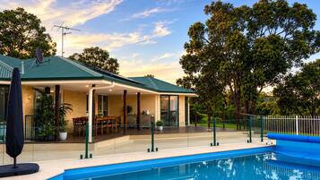 A house with a pool, outdoor seating, and a covered patio.