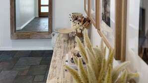 A hallway with a wooden door, a mirror, and a wall with framed pictures. - Private Estuary Retreat | Pool & Sunrise Views - 1.5hrs from Perth (Herron)