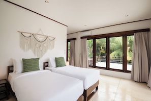 A hotel room with two beds, a macrame wall hanging, and a large window with curtains. - Dream View Villa - 5 Br (Pecatu)