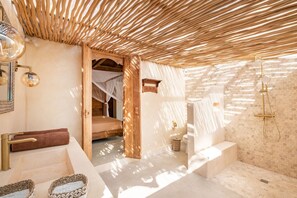 A modern bathroom with a bathtub, shower, and a wooden ceiling. - Villa We We - 1 Br (Pecatu)