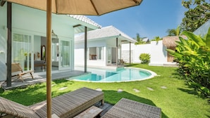 A modern house with a swimming pool, outdoor furniture, and a well-maintained lawn. - Bingin Beach Villas (Pecatu)