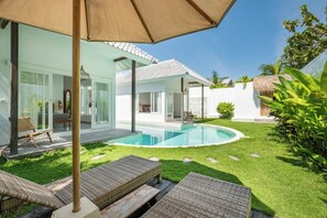 A modern house with a swimming pool, outdoor furniture, and a well-maintained lawn. - Bingin Beach Villas (Pecatu)