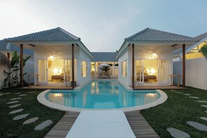 A poolside area with two connected rooms, a pool, and a wooden deck. - Bingin Beach Villas (Pecatu)