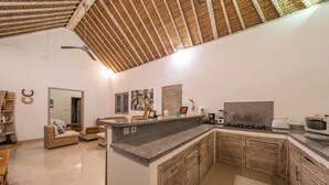 Eine moderne Küche mit Granit Arbeitsplatte, Holzschränken und Deckenventilator.