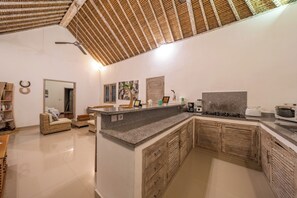 Eine moderne Küche mit Granit Arbeitsplatte, Holzschränken und Deckenventilator.