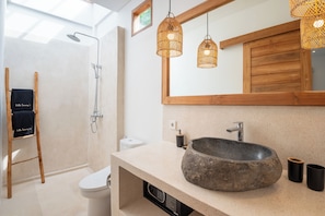 Ein modernes Badezimmer mit einer freistehenden Badewanne, einem großen Spiegel und einem hölzernen Waschtisch.
