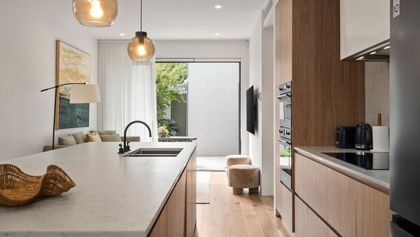 A modern kitchen with a central island, pendant lighting, a built-in oven, and a view to the outdoors. - Loft & Leaf Terrace Stanmore (Stanmore)