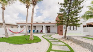 A modern house with a patio, a hammock, and a well-maintained lawn. - 2 min Walk to Beach - Mangel Halto (Savaneta)