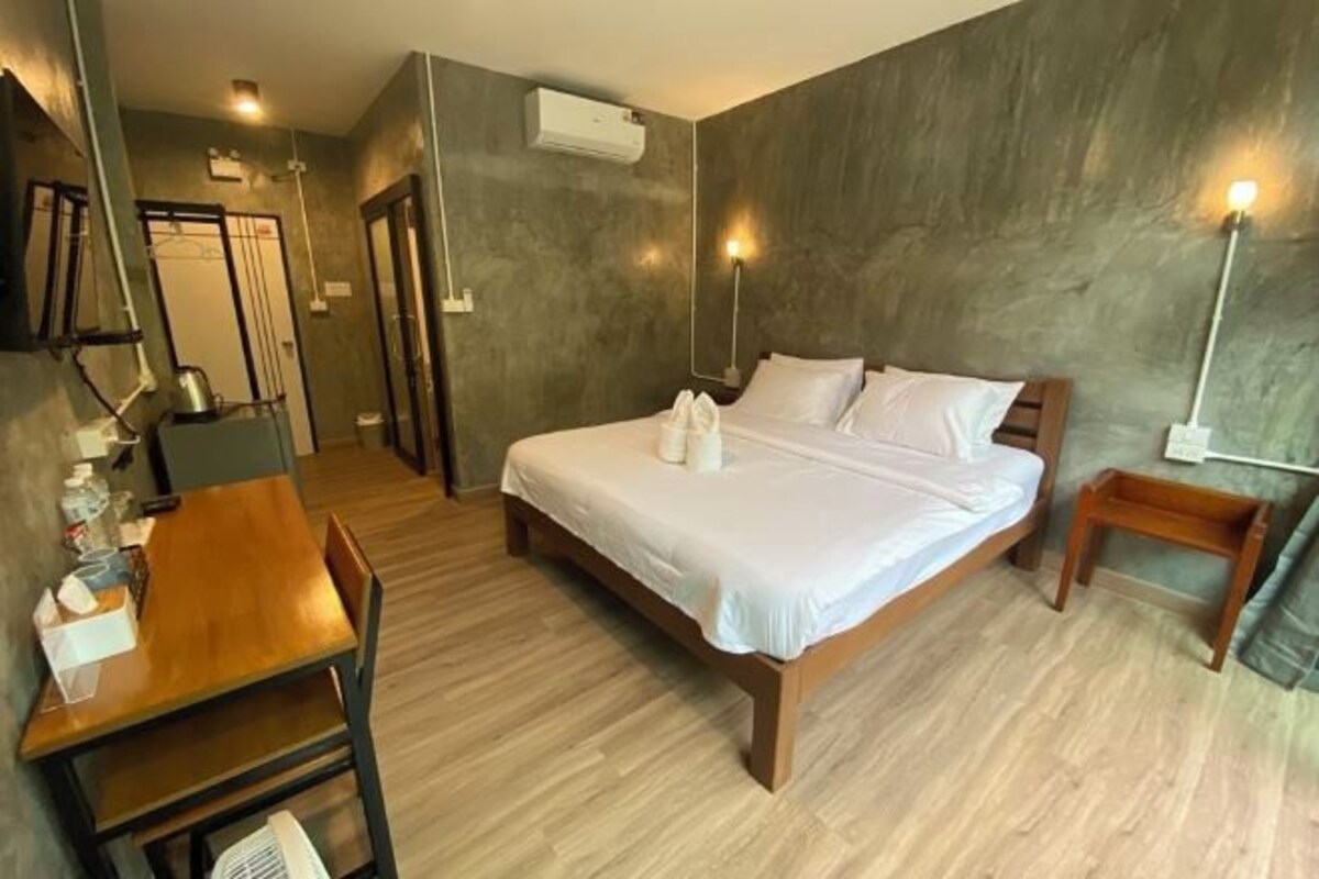 Un dormitorio con una cama de madera, un escritorio y una silla.