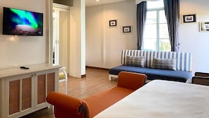 A hotel room with a bed, a sofa, a television, a cabinet, and a window with curtains. - The Boone resort (Doi Saket)