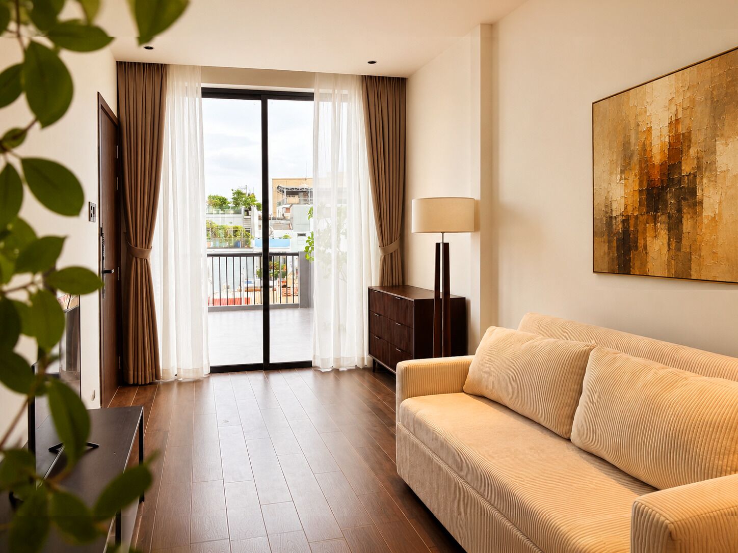 A modern living room with a sofa, a lamp, a painting, and a view through a sliding door.