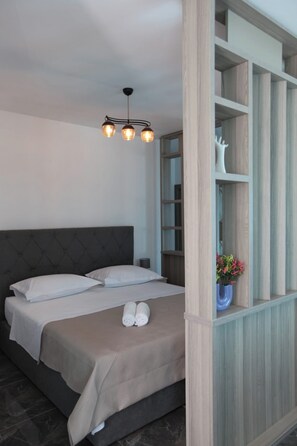Un dormitorio con cama, lámpara colgante y estantería empotrada.