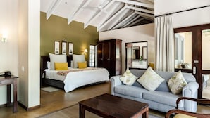 A bedroom with a bed, a sofa, a coffee table, and a desk. - Perry's Bridge Hollow Boutique Hotel (Mbombela)
