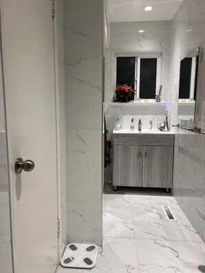 Een douche, handdoeken, zeep, toiletpapier
