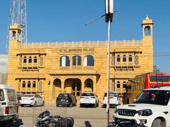 A building labeled 'Hotel Bhargav Palace' with a prominent entrance, multiple windows, and a clock tower. - Hotel Bhargav Palace (Jaisalmer)