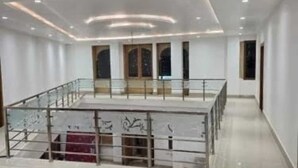 A spacious hotel lobby with a high ceiling, recessed lighting, a glass railing, and a marble floor. - Hotel Bhargav Palace (Jaisalmer)