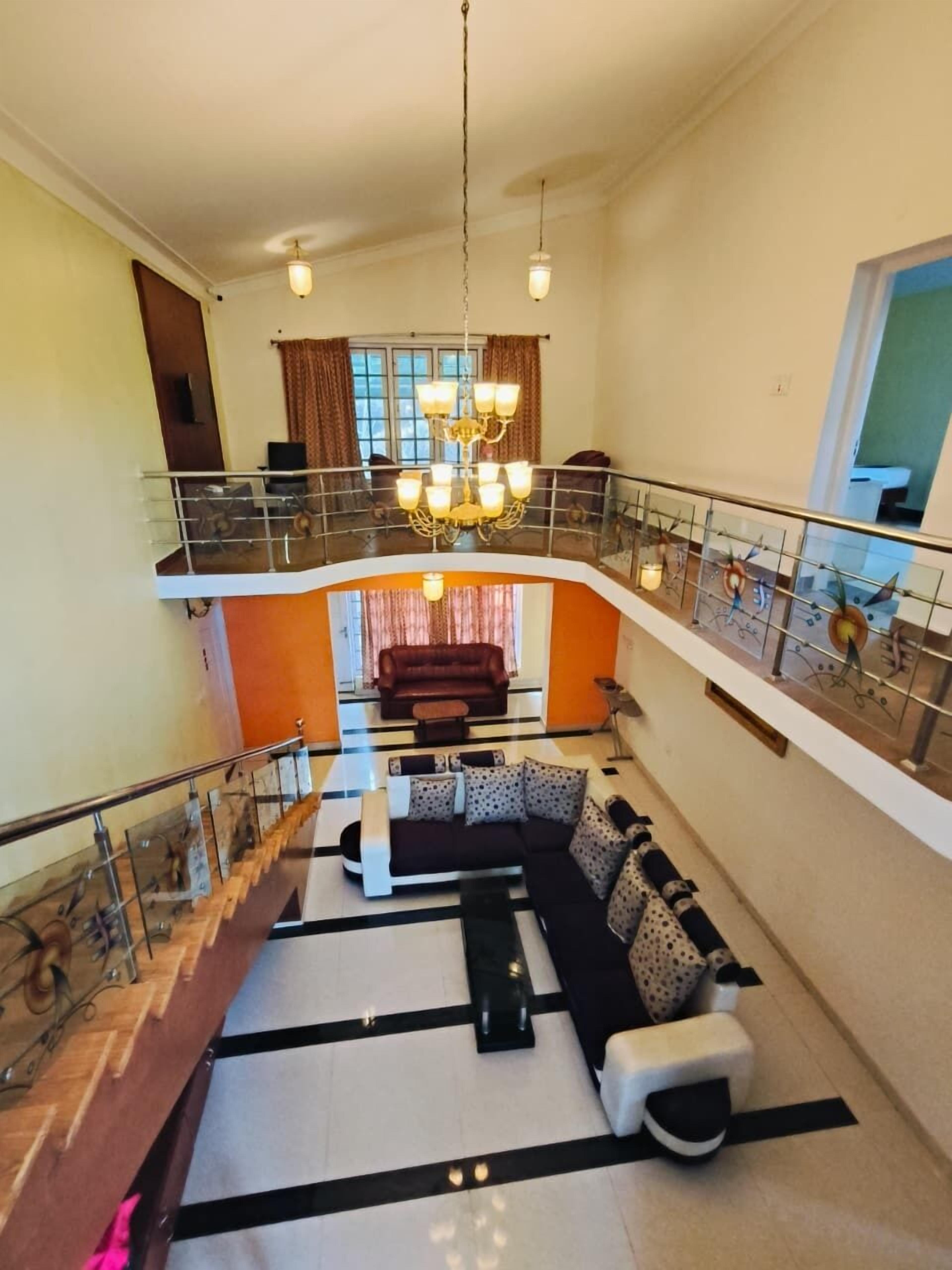 A spacious living area with a sofa set, a coffee table, and a chandelier.