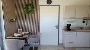 Een moderne keuken met een koffiezetapparaat, een klok en een plant.