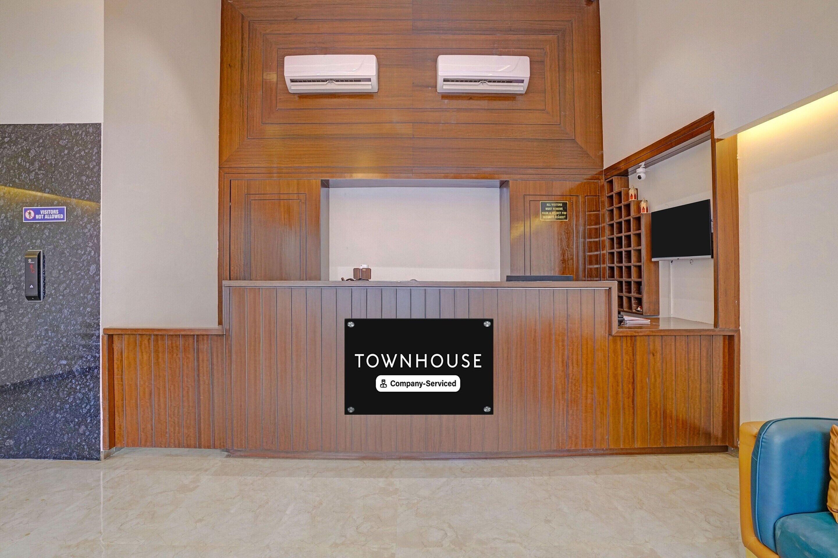 Una mesa de recepción con un cartel que dice 'TOWNHOUSE Company-Serviced'.