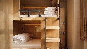 Habitación con literas, escritorio y una pequeña estantería.
