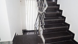 A staircase with a metal handrail, leading to a door with vertical blinds. - Perfect 5-bedroom hotel with AC in pleasant Varanasi (Varanasi)