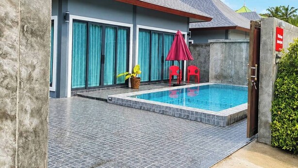 A modern building with a swimming pool, a covered area with red chairs, and a large window with curtains. - Villa Escape , Aonang Krabi (Meung krabi)