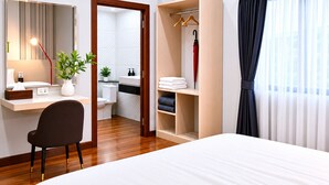 A hotel room with a bed, a desk with a chair, a wardrobe, a bathroom, and a large window with curtains. - Villa Escape , Aonang Krabi (Meung krabi)