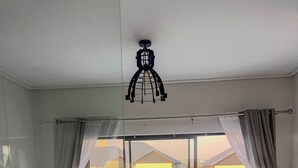 Habitació d'hotel amb llit, sofà, taula de dinar i vista a un pati amb mobiliari exterior.