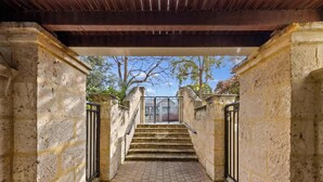 A stone staircase leading to a covered area with a view of trees and a clear sky. - 15 Calm & Cosy w Parking - Walk to Beach & Train (Mosman Park)
