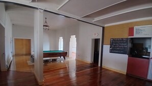 A spacious room with a pool table, a billiards table, and a chalkboard menu on the wall. - Five Mile Hotel - America's Most Famous Roadhouse (Butte)