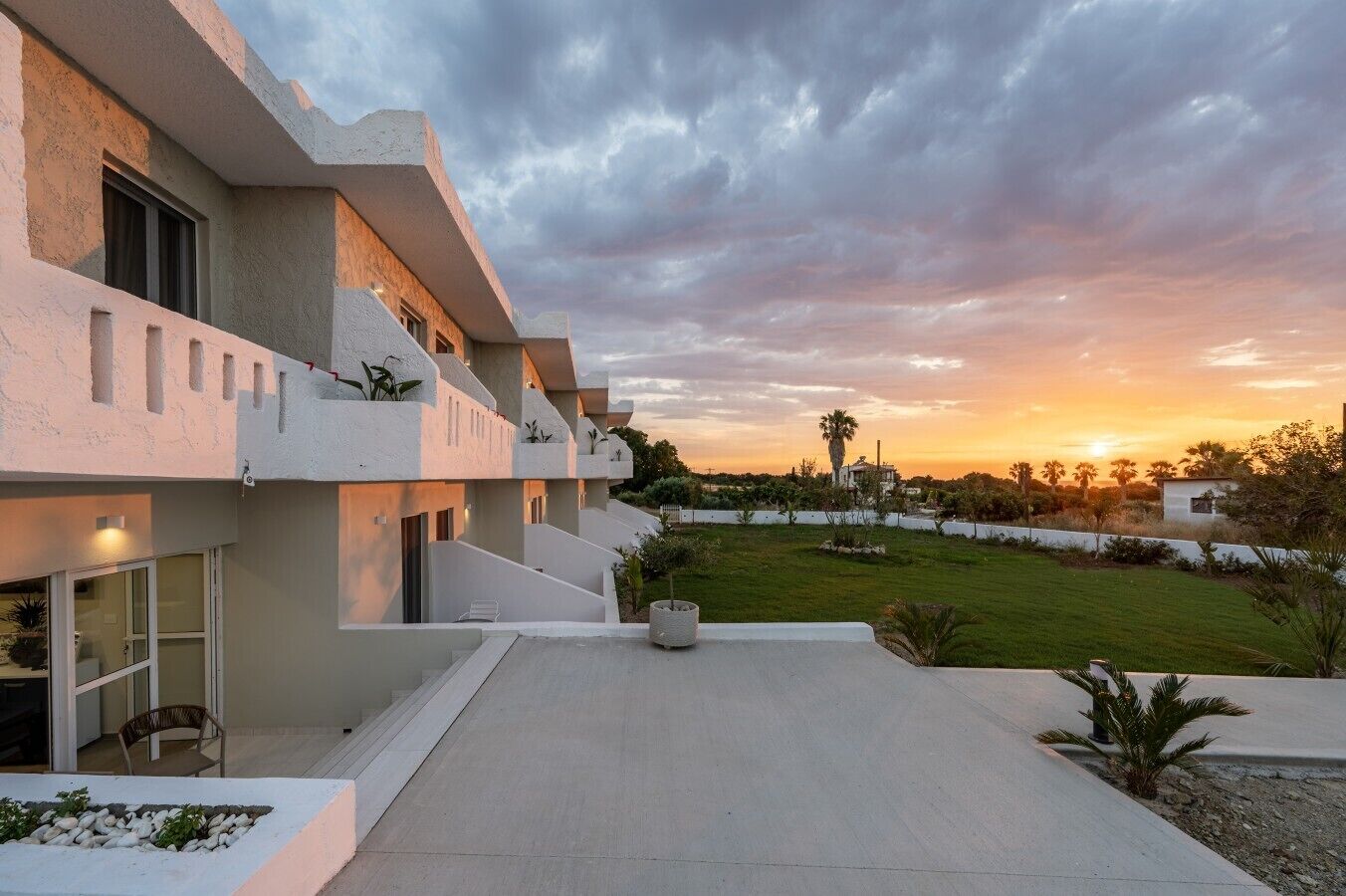Un edificio moderno con techo plano, ventanas amplias y un césped bien cuidado.