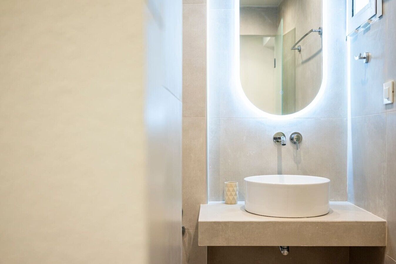 A bathroom with a round sink, a mirror, and a shower.