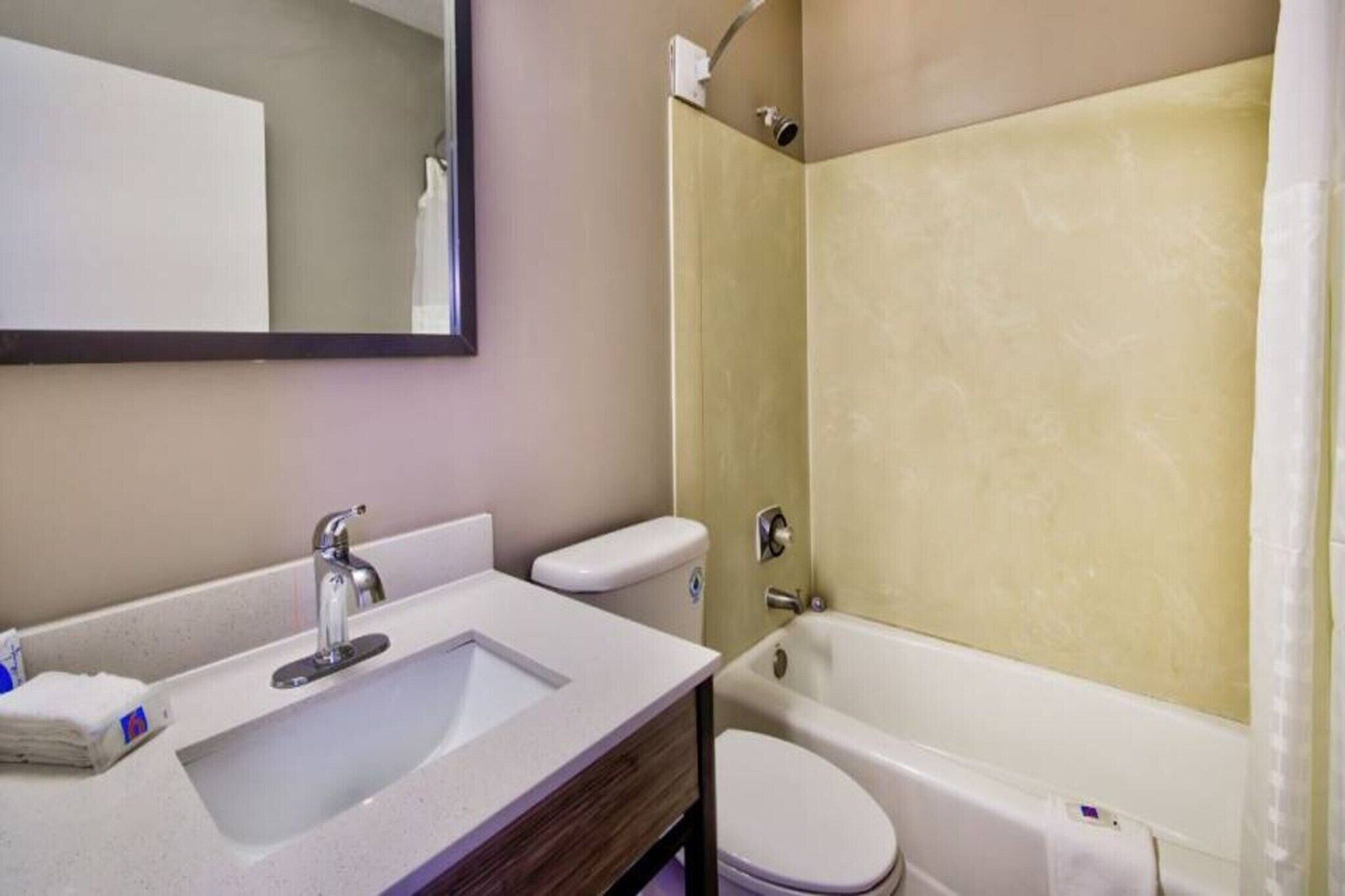 A bathroom with a sink, toilet, and bathtub.