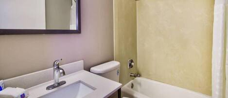 A bathroom with a sink, toilet, and bathtub.