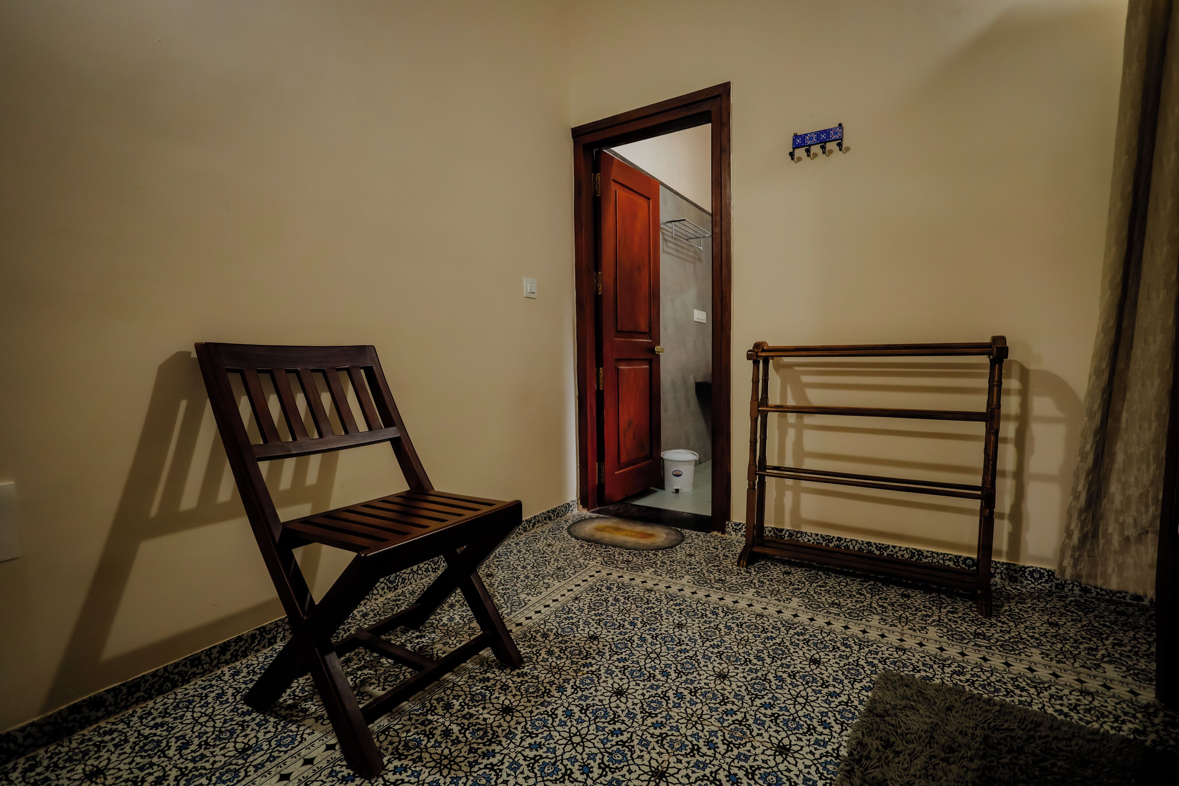 A room with a wooden chair, a small table, and a patterned floor.