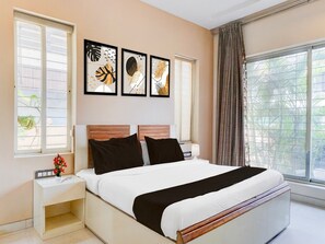 Ein Schlafzimmer mit einem Bett, Nachttischen und Kunstwerken an der Wand.