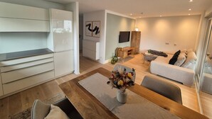 A modern living space with a kitchen, dining area, and seating area. - Premium Lake Constance Base Apartment – Modern, Cozy & Well-Maintained (Rielasingen-Worblingen)