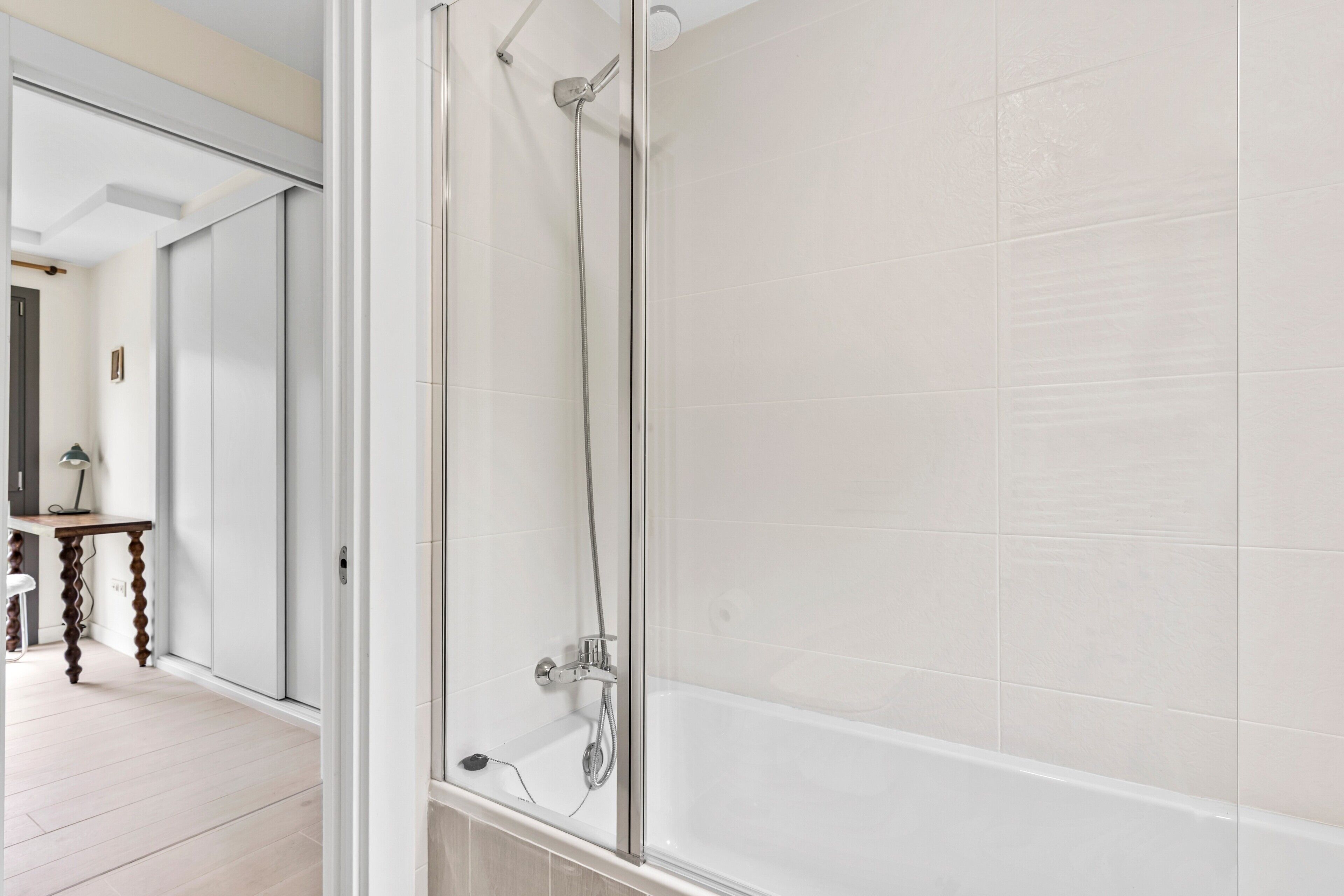 A bathroom with a glass-enclosed shower, a bathtub, and a mirror.
