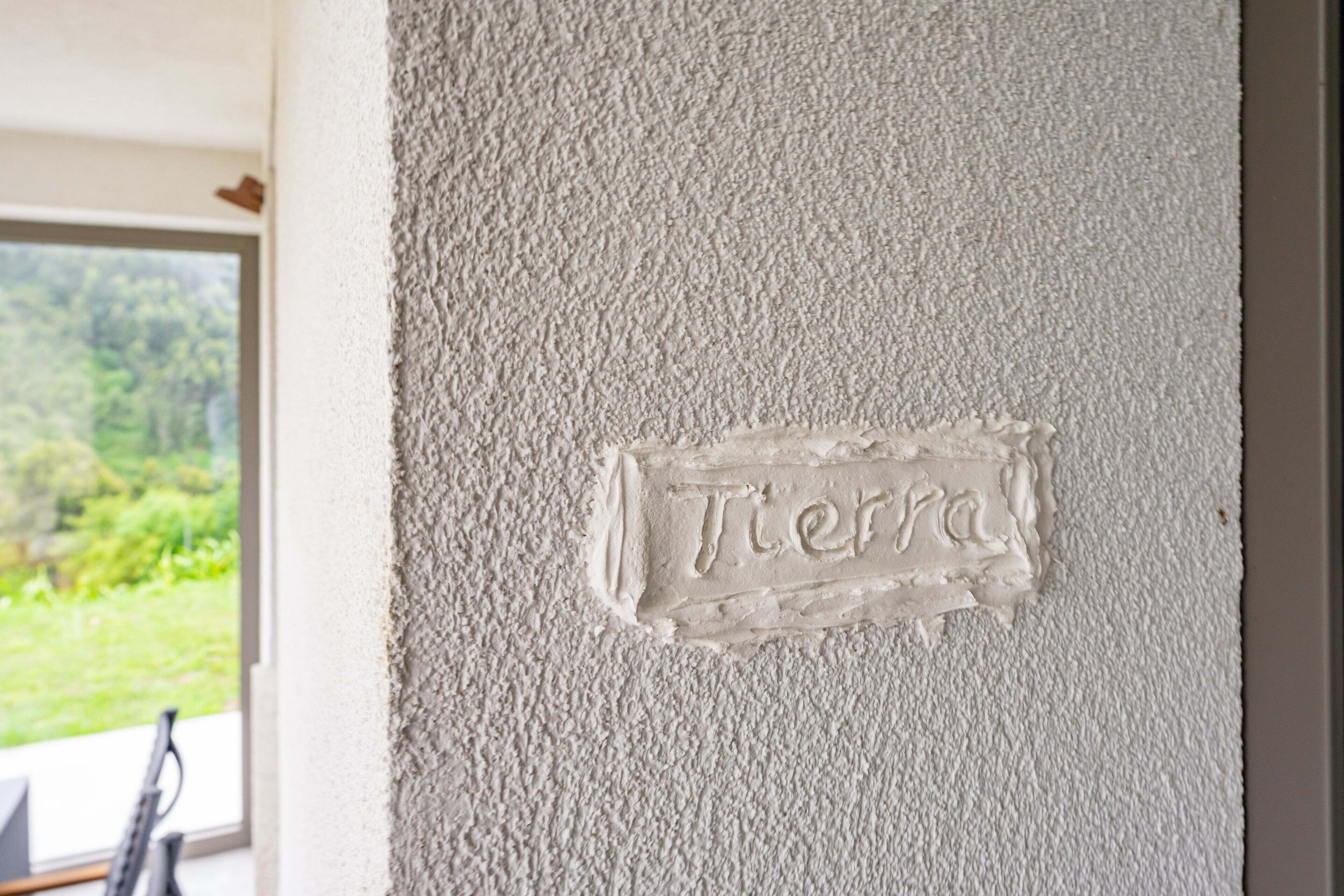 A textured wall with a plaque reading 'Tierra.'