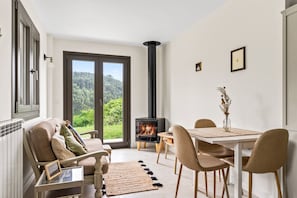 Una sala de estar acogedora con chimenea, comedor y vistas al exterior.