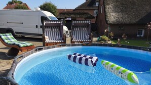 A swimming pool with lounge chairs, a hot tub, and a van in the background. - Vacation apartment WESER im Relax - Belum near Otterndorf LK Cuxhaven (Belum)