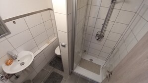 A bathroom with a shower, toilet, and sink. - Vacation apartment WESER im Relax - Belum near Otterndorf LK Cuxhaven (Belum)