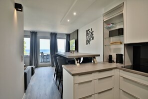 A modern kitchen with a dining area, a view to the outside, and a wall with a motivational quote. - Strandkoje 203 - Holiday apartment Scharbeutz directly on the beach - Strandkoje 203 for (Scharbeutz)