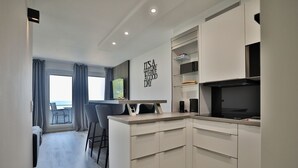 A modern kitchen with a dining area, a view to the outside, and a wall with a motivational quote. - Strandkoje 203 - Holiday apartment Scharbeutz directly on the beach - Strandkoje 203 for (Scharbeutz)
