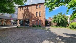 A brick building with a covered entrance, a gravel driveway, and a clear sky. - Fewo 1 im Alten Zollhaus Stralsund - Holiday apartment 1 in the old customs house directly at the (Stralsund)