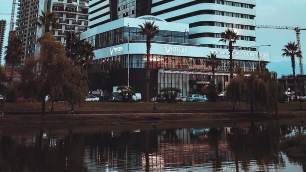 Een modern hoog hotel met een gebogen gevel, meerdere verdiepingen en een centraal atrium.