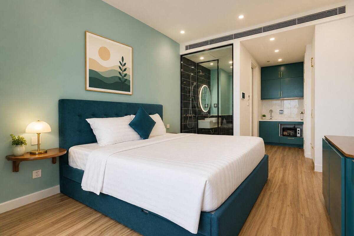 Un dormitorio con cama, mesita de noche, lámpara y un cuadro en la pared.