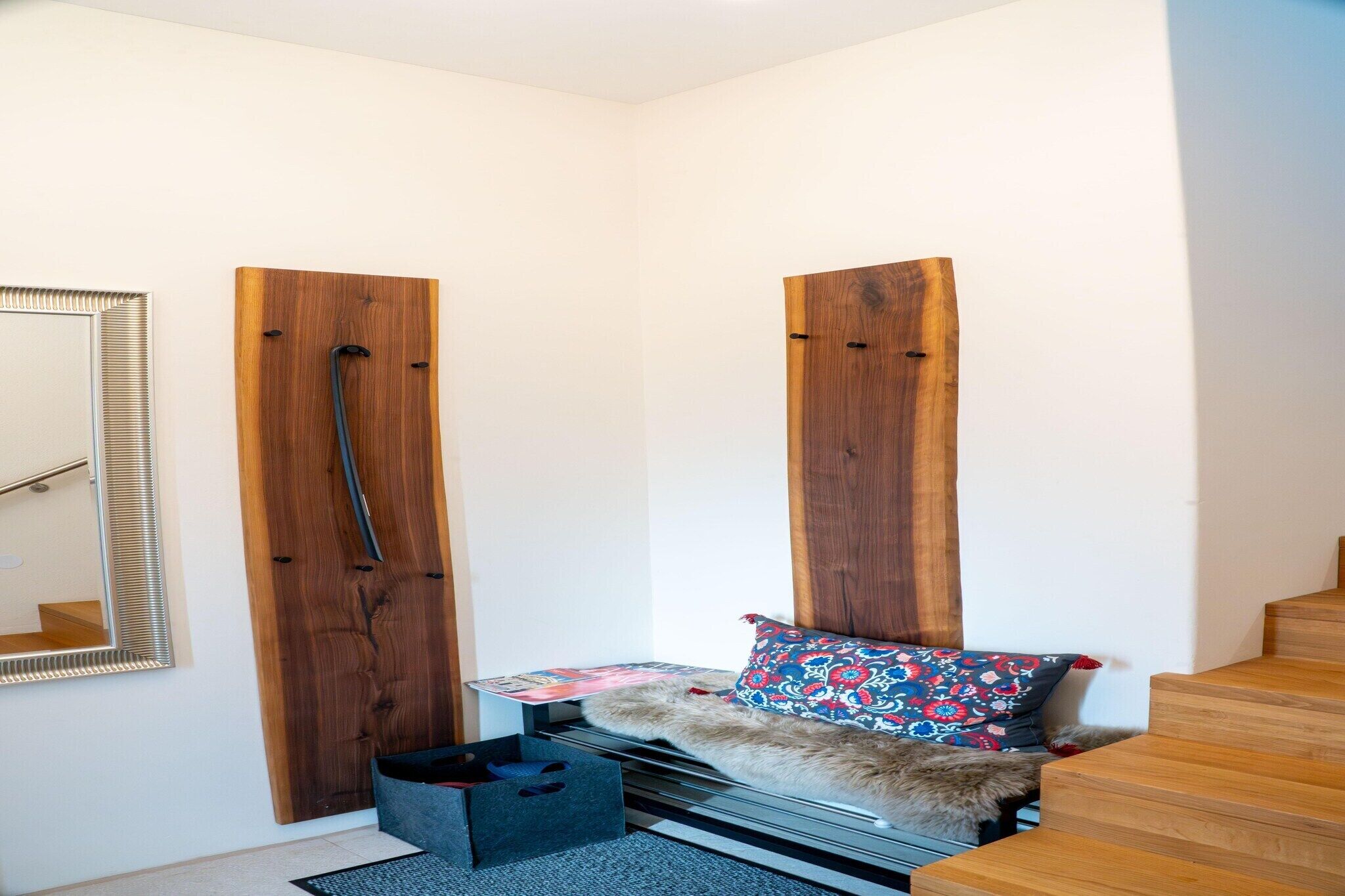 Une pièce avec un lit, un miroir, une porte en bois et un escalier.