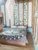 Una habitación con una cama, un mosquitero y una pared con la inscripción 'VIVE HOY'.