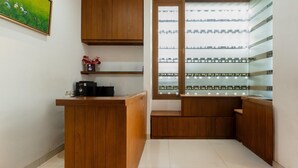 A reception area with wooden counters, a shelf with decorative items, and a glass display case. - Modern Deluxe Double in Cirebon (Cirebon)